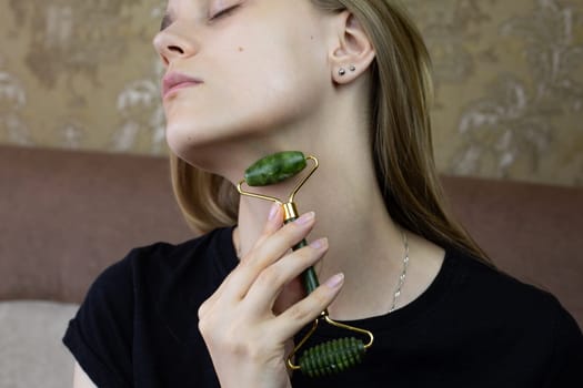 Young girl massages her neck with roller to smooth out wrinkles and take care of skin, caring for the girl body using special tool