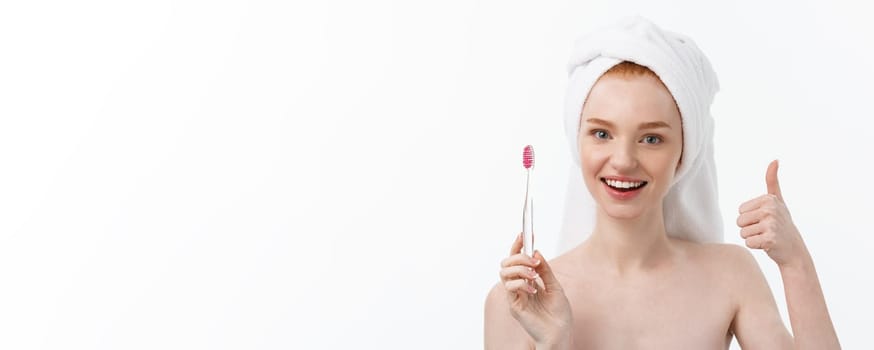 Portrait of young woman with toothbrush on grey background