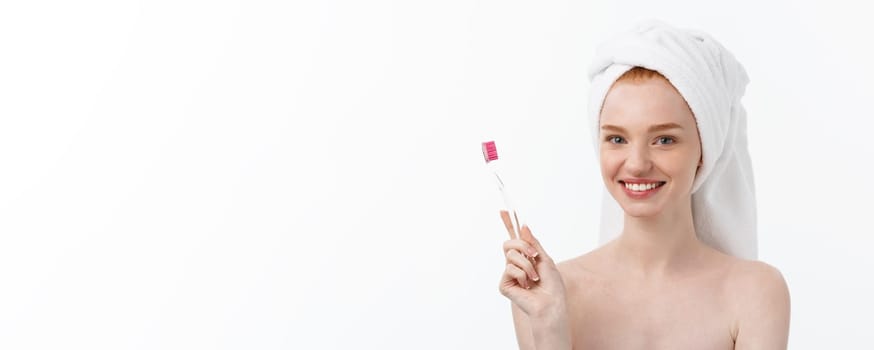 Portrait of young woman with toothbrush on grey background