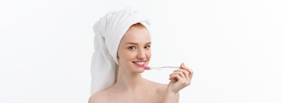 Portrait of young woman with toothbrush on grey background