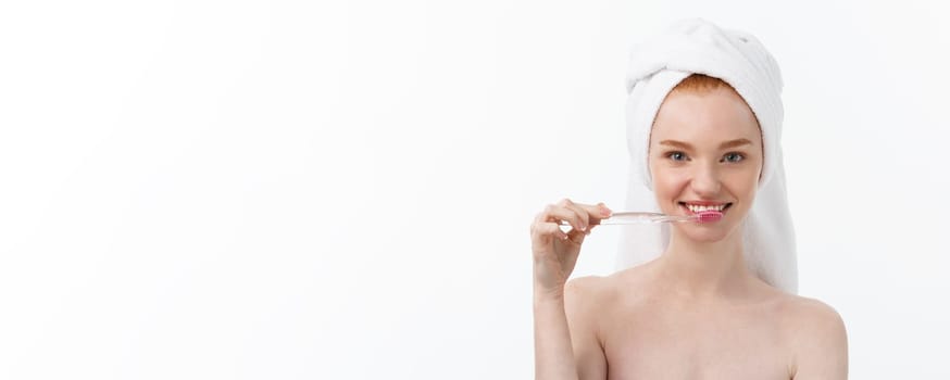 Portrait of young woman with toothbrush on grey background