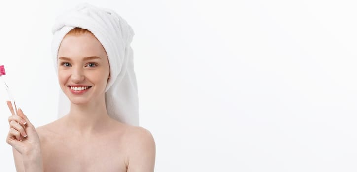 Portrait of young woman with toothbrush on grey background