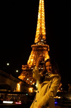 Girl with a glass against the backdrop of the glowing Eiffel Tower in. High quality photo