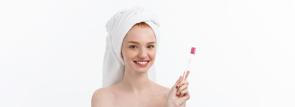 Portrait of young woman with toothbrush on grey background