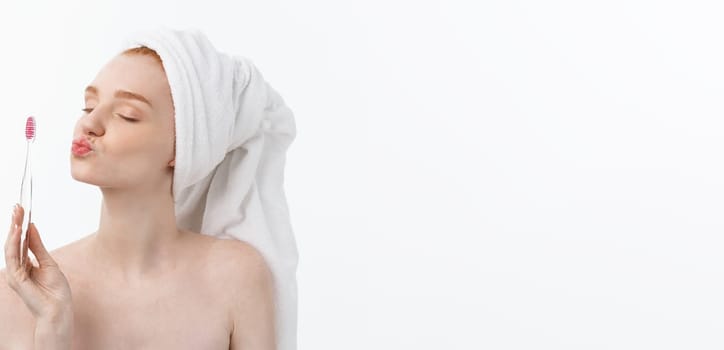 Portrait of young woman with toothbrush on grey background