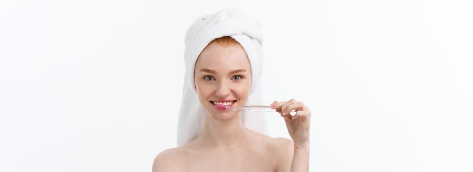 Portrait of young woman with toothbrush on grey background