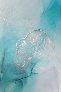 A close-up abstract image of teal and silver ink swirling and mixing together, creating a unique and intricate pattern.