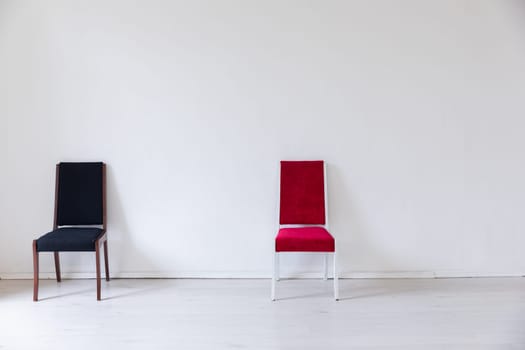a red and black chairs in the interior of the white room