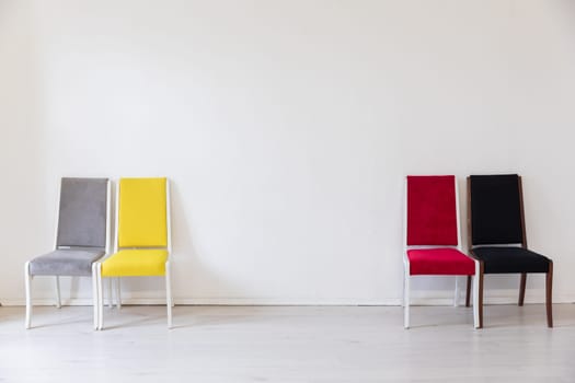 a bright room with four chairs grey red yellow black