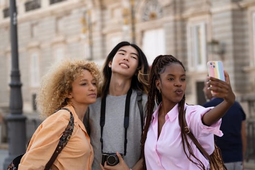 Group of multiethnic young tourists taking a selfie while visiting Madrid city.