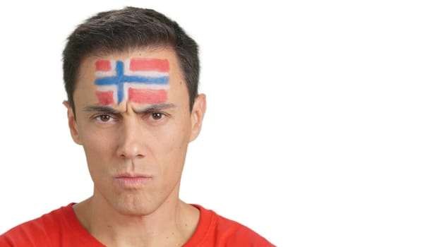 Close up of a serious man with a norwegian flag painted on the face looking at camera