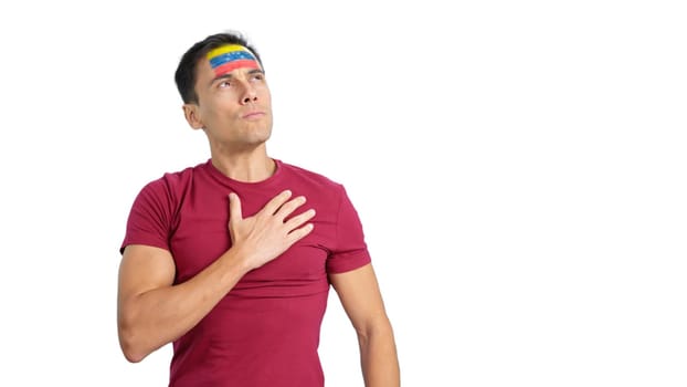 Photo of a man listening to the Venezuela national anthem with solemnity