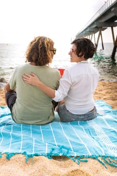 Smiling couple with sunglasses enjoying a vacation looking at the sea.Vertical