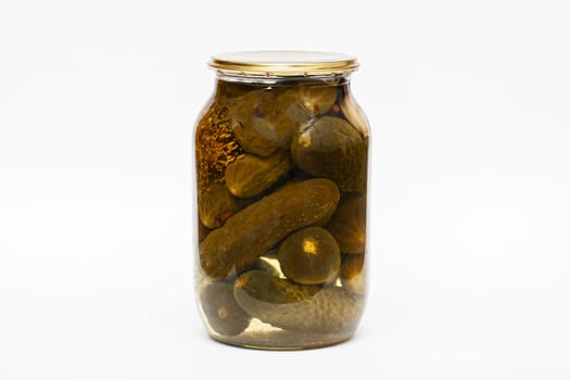 Pickled cucumbers in a transparent jar isolated on white background.