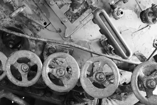 Black and white image of Five red valve taps from an abandoned retro locomotive.