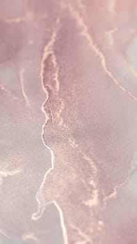 A close-up image of a pink and rose gold abstract design, with swirling patterns.