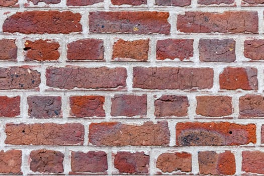 A brick wall with a white border. The wall is made of red bricks and has a white border