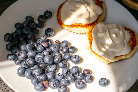 Shot of the breakfast plate with home made cheesecakes with sour cream and blueberries