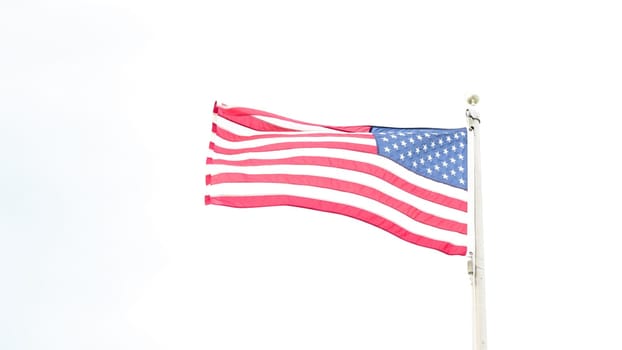 Beautiful American flag waving in the wind, with vibrant red white and blue colors against blue sky, with copy space