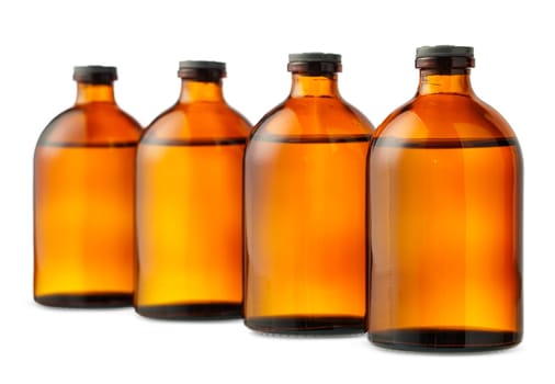 Four amber glass bottles with black screw caps stand in a row on a white background.