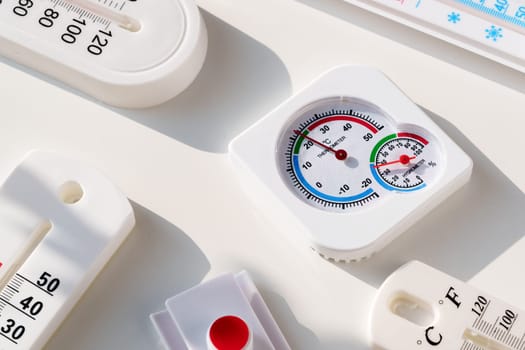 This image shows several white plastic thermometers laid out on a white surface.