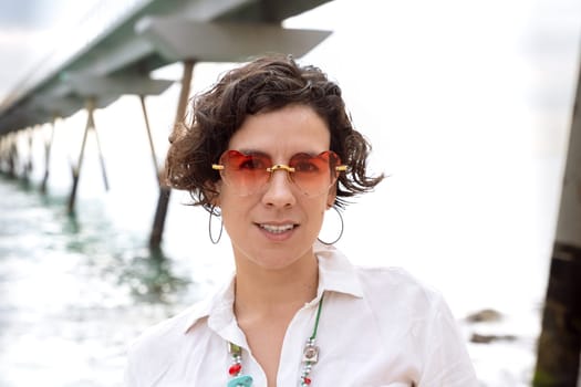 Caucasian woman wearing smiling sunglasses looking at camera. young on vacation on the coast.