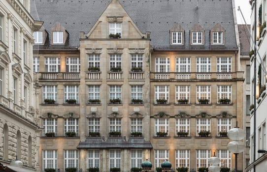 Munich, Germany - Dec 21, 2023 - Exterior architecture of Kaufingerstr11a Building with Windows with flower pots. Traditional bavarian architecture. Space for text, Selective focus.