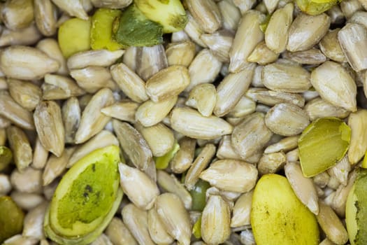 Close-up of a mix of sunflower seeds and other nutritious seeds. The detailed shot captures the natural textures and colors of the seeds, making it ideal for use in projects related to healthy eating, nutrition, and natural food products.