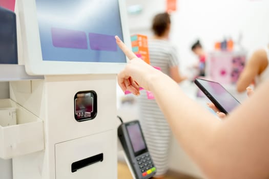 Girl Pays For Purchase At Self-Service Checkout, Close-Up Of Hands