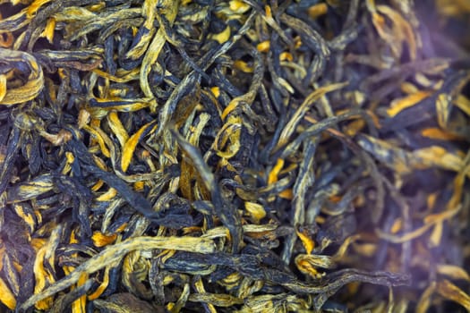 Close-up view of loose leaf black tea. The image captures the intricate textures and natural colors of the dried tea leaves, making it ideal for use in projects related to beverages, tea culture, and gourmet foo