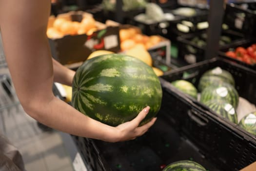 Young Girl In Store Choosing Watermelon, Close-Up Of Hands