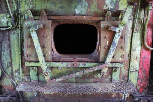 A close-up fragment of the open firebox in the engine of an abandoned retro locomotive.