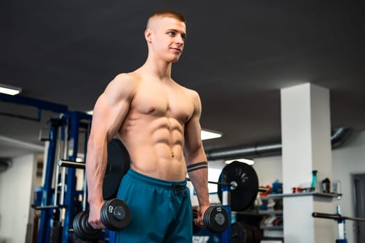 A muscular man lifts weights in a gym during a workout session