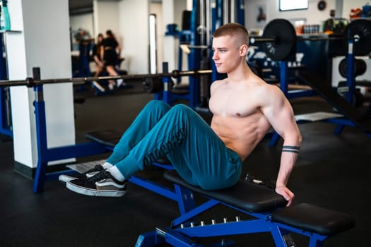 A professional bodybuilder works out his abs at the gym.