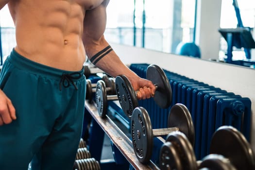Bodybuilder holding a dumbbell in the gym