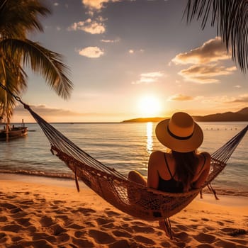 A woman in a hammock on a beach at sunset.