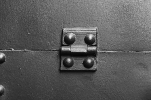 Fragment of protective armor, shield flap with a hinge, rivets, close-up.