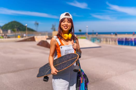 Portrait with copy space of a happy young asian woman in skate park