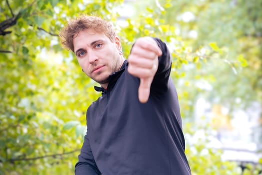 Happy man looking at camera pointing finger down Man resting during his morning workout.