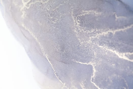 A close-up of a gray marble texture with white veins. The image is abstract and could be used as a background.