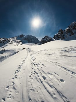 High mountain winter scenic trail, magnificent vertical landscape on a sunny winter day.