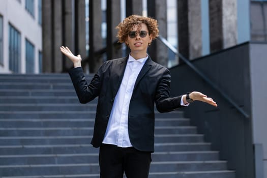 I don't know what to say. Confused business man standing outside office workplace. Young manager feeling embarrassed about ambiguous question, having doubts, no answer idea, being clueless, uncertain.