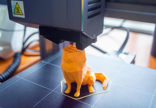 3D printer close-up. The process of working of 3D printer. 3D printer printing object from molten plastic. 3D printer creating model by flowing liquid plastic from an extruder. Printing technology