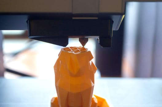 3D printer close-up. The process of working of 3D printer. 3D printer printing object from molten plastic. 3D printer creating model by flowing liquid plastic from an extruder. Printing technology