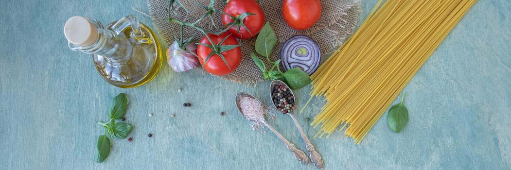 Banner of ingredients, spaghetti, red ripe tomatoes, olive oil, green basil, parmesan cheese, onion, garlic and spices. pasta recipe with tomatoes or pasta al pomodoro. flat lay on wooden background with copy space.