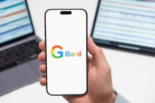 PRAGUE, CZECH REPUBLIC - JANUARY 21 2024: G Bard logo on the screen of smartphone in mans hand on the workplace background.