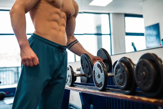 A bodybuilder gripping a dumbbell at the gym