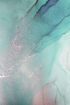 A close-up image of abstract teal and silver ink swirling together, creating a unique and artistic pattern.