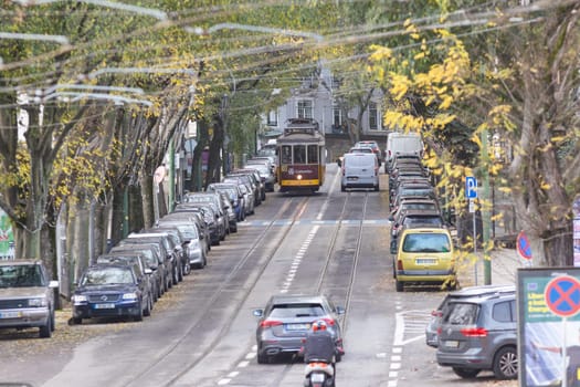 11 december 2023, Lisbon, Portugal - A busy street with a old tram metro running down the middle There are many cars and a motorcycle