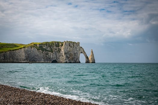 Landscape photo of tall, steep limestone cliffs by the ocean with one with a hole in it creating an arch, the elephant rock with the sea as foreground
